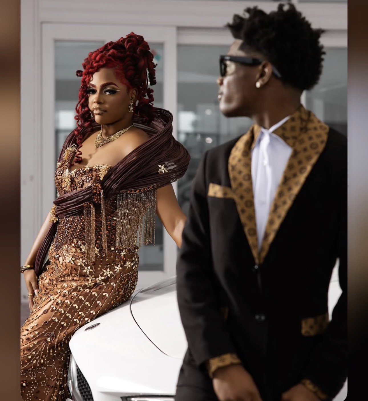 Prom couple in custom bronze beaded gown beside car